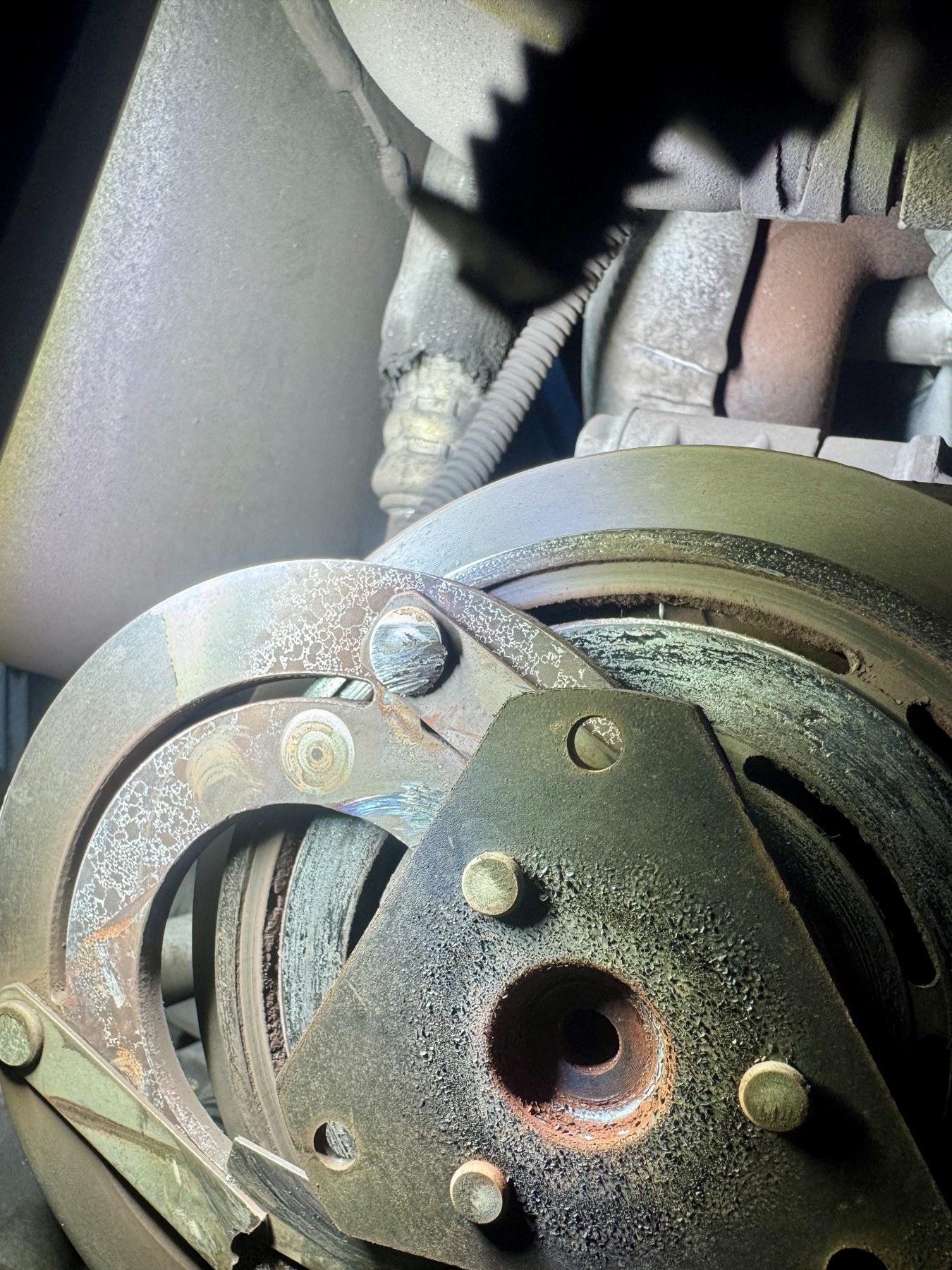 Close view of the failed Corvette A/C clutch face and hub beside the pulley.