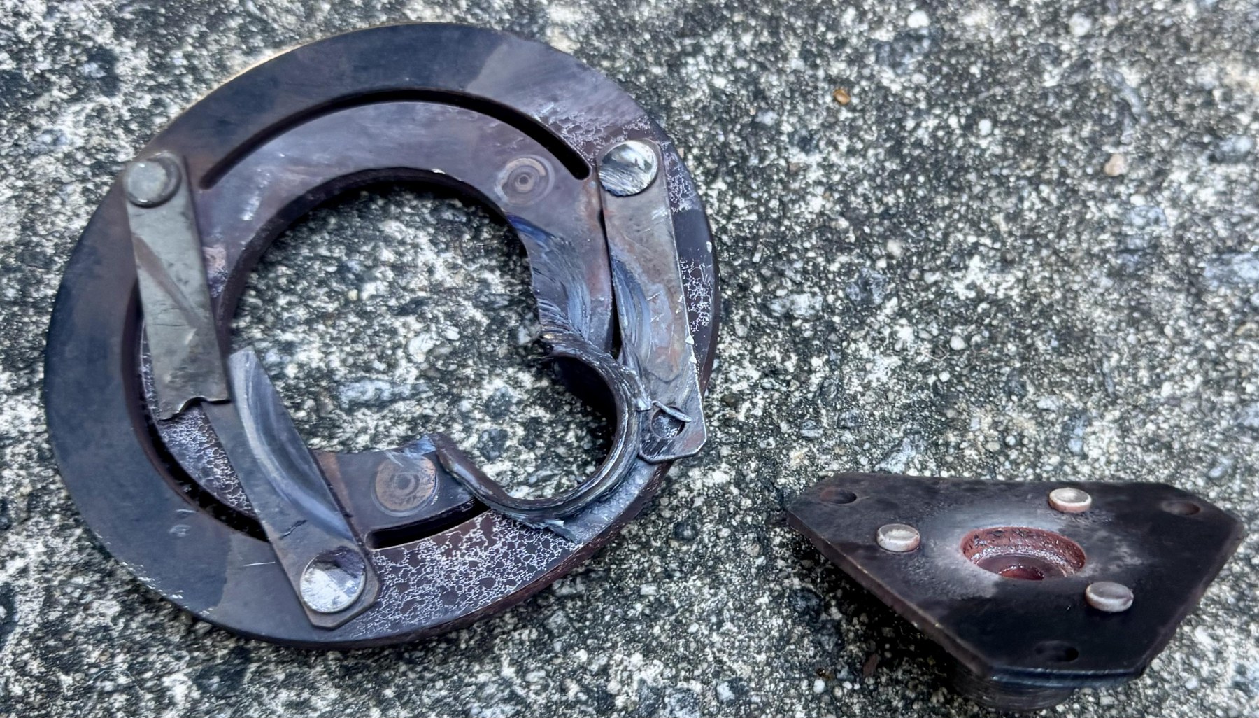 Removed Corvette clutch face with a damaged opening and the separated hub alongside it.