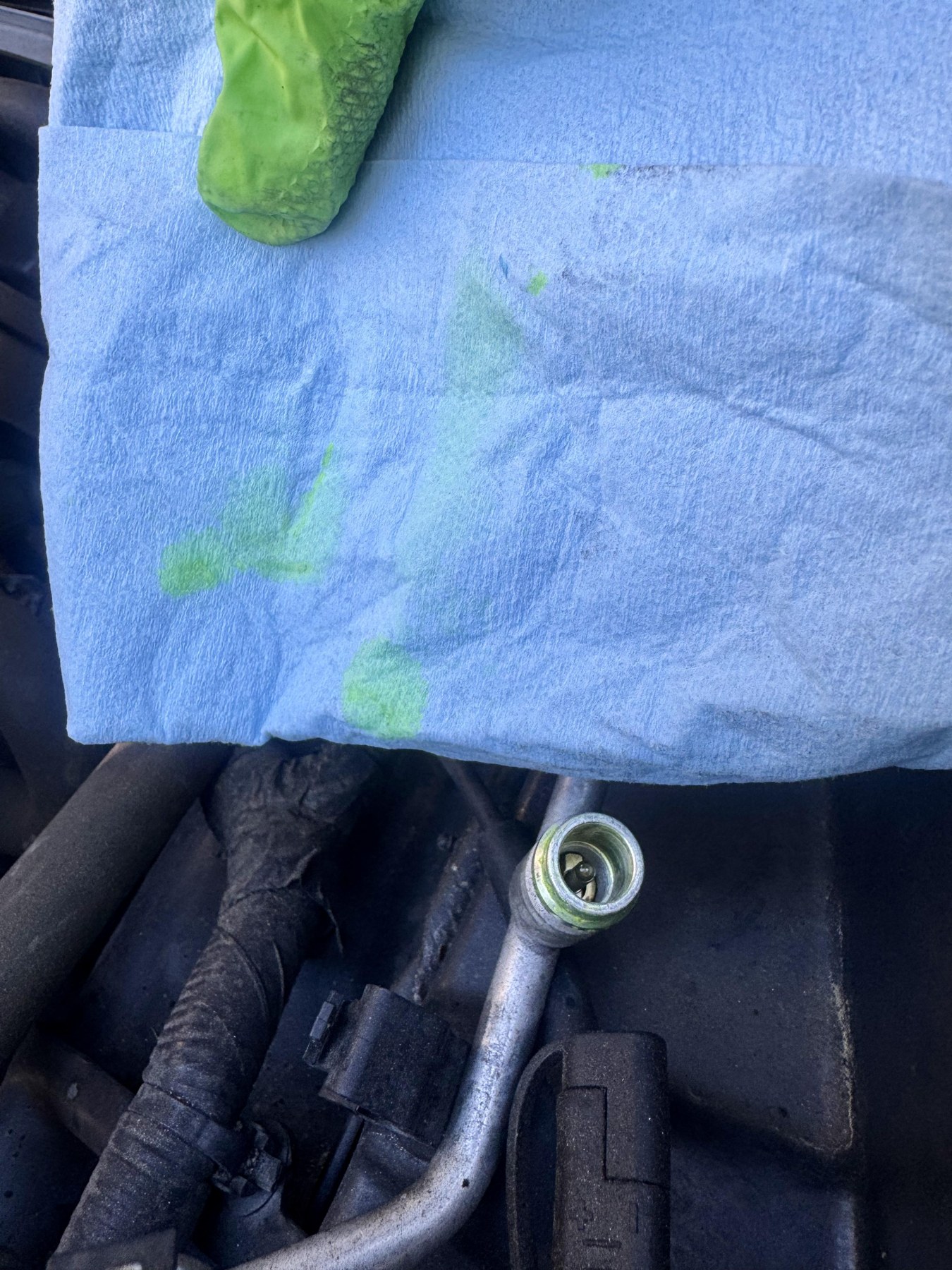 Oil sample on a blue shop towel above the Corvette A/C high-side service port.